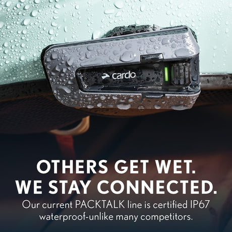 Cardo Packtalk device on a car dashboard with water droplets, emphasizing waterproof certification.